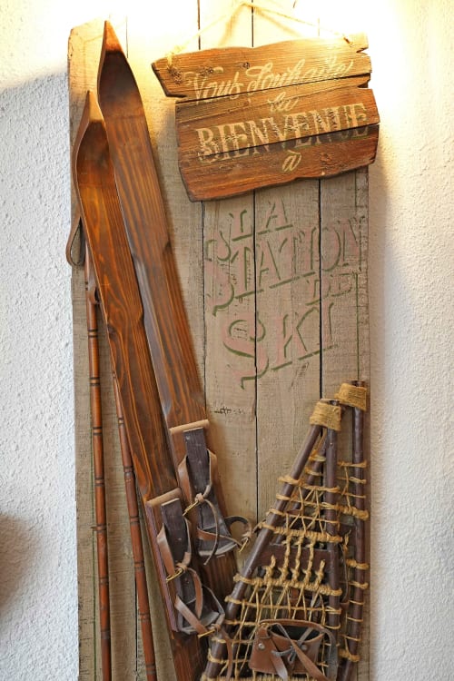 Anciens skis et raquettes accrochés au mur en bois du gîte alpin L'étape Du Fanfoué à Chamrousse