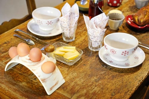 Table du petit-déjeuner à la Guesthouse L'étape Du Fanfoué à Chamrousse avec œufs, beurre, thé et vaisselle festive