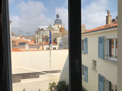 View from Hôtel Maison Richet suite in Les Sables-d'Olonne overlooking rooftops and cathedral