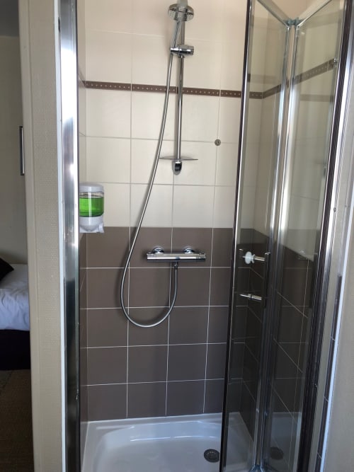 Modern shower enclosure with chrome fixtures at Hôtel Maison Richet Les Sables-d'Olonne