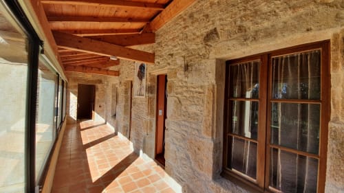 Coursive lumineuse du Gîte Jade avec murs en pierre et accès aux chambres