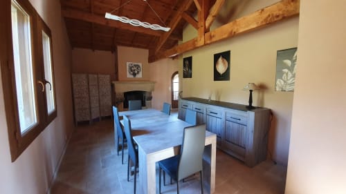 Comedor espacioso del Gîte Jade con vigas vistas y muebles de madera, ideal para comidas en familia o con amigos