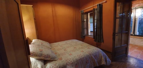 Dormitorio del Gîte Jade con acceso a la galería de piedra, cama doble y luz natural