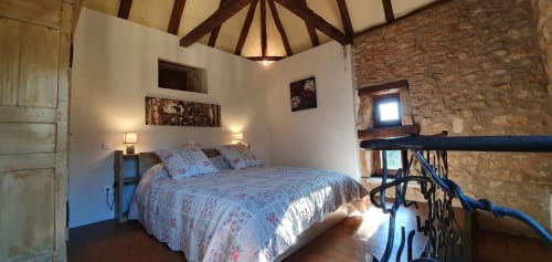 Dormitorio doble en el palomar del Gîte Jade, con muros de piedra y vigas vistas típicas del Lot, ambiente tranquilo y luminoso