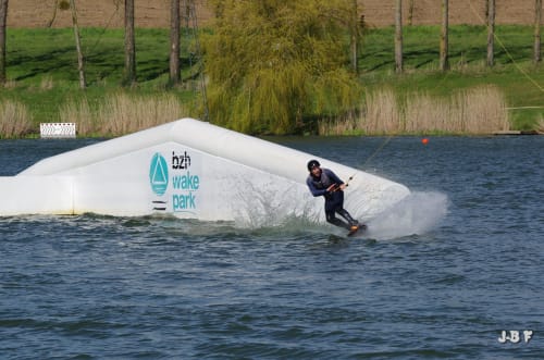 Wakeboarder sur une vague au BZH Wake Park près des Forges du Lou à Jugon-les-Lacs, France