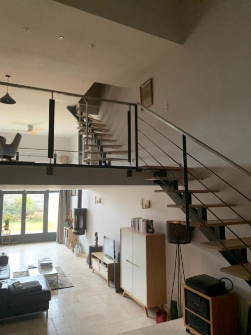 La pièce à vivre et les escaliers menant à la salle à manger et aux chambres.