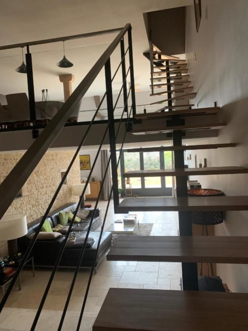 La pièce à vivre et les escaliers menant à la salle à manger et aux chambres.