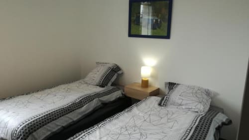 Chambre double à la Résidence des dunes B&B à Landéda avec lampe de chevet et tableaux encadrés
