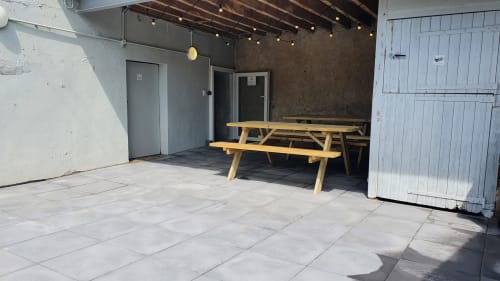 Outdoor patio at Locacharme cottage in Blois with wooden picnic table and string lights
