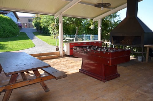 Barbacoa cubierta con tejavana. Espacio de recreo con futbolín, mesa de bodega , barbacoa grande con espacio para dos parrillas. Rueda de butano para hacer paellas, con varia paelleras de distintos tamaños, rancheras...