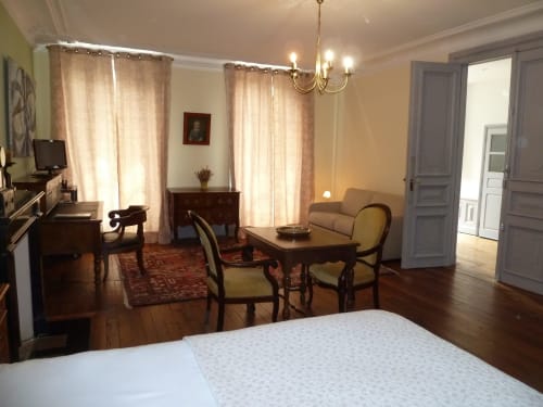 Habitación Montespan en el Château De Clusors B&B en St Menoux, Francia con cama, escritorio, mesa de comedor y vista al jardín