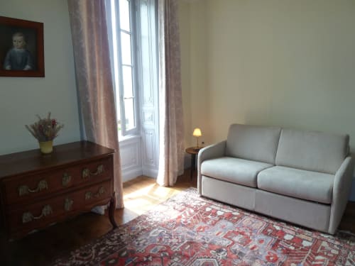 Habitación Montespan en Château De Clusors con sofá gris, cómoda antigua y puertas con vistas al jardín en ST MENOUX, Francia
