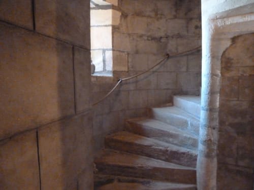 Escalera de piedra con barandilla metálica en la habitación Montespan del Château De Clusors, histórica casa de huéspedes francesa en St Menoux