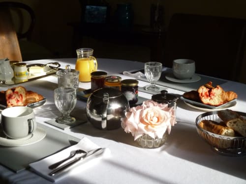 Elegante mesa de desayuno en Château De Clusors con cruasanes, flores frescas, zumo y servicio de alta cocina en St Menoux