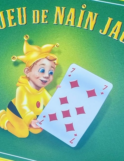 Personnage de bouffon joyeux tenant une carte sept de carreau, promouvant le gîte La Dragonne à Bellême, en France