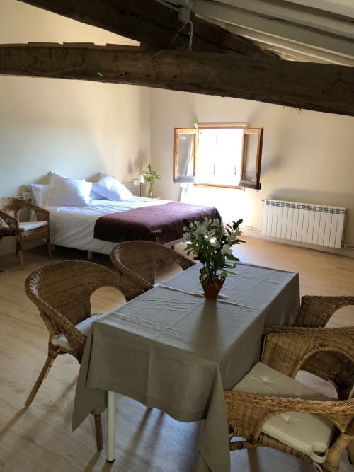 Dormitorio La Guineu en Casa Tapiolas de Molló con cama, sillas de mimbre, mesa de comedor y vistas a la montaña