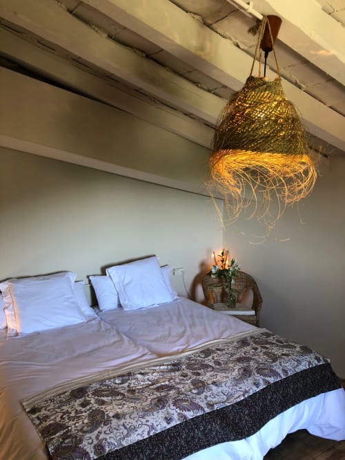 Acogedora habitación en Casa Tapiolas en Molló con ropa de cama blanca, lámpara colgante de tejido y vistas a la montaña