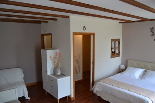chambre spacieuse avec poutres apparentes au logis de la Bénétière