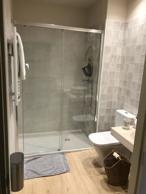 Baño moderno en Casa Tapiolas con ducha acristalada, inodoro y lavabo en Molló, Girona