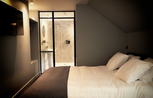 Chambre moderne au Petit Château B&B avec salle de bain privée, draps blancs et vue sur le jardin à Baye