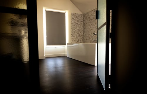 Modern bathroom at Le Petit Château Baye with dark flooring, white fixtures, and terrazzo wall tiles