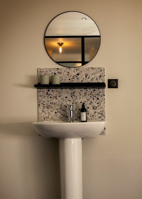 Vasque moderne avec miroir rond reflétant la vue sur le coucher de soleil au Petit Château, Baye