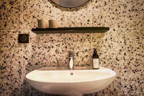 Modern wastafel met terrazzo tegels in de Balthazar kamer van Le Petit Château B&B, Baye