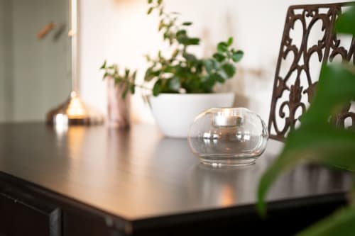 Elegant table setting at Espace Ker Gana with glass candle holder, potted plants, and decorative elements in Plourin, FR