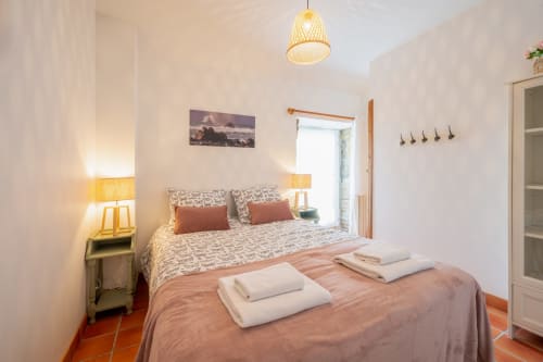 Bright bedroom at Espace Ker Gana in Plourin with twin beds, terracotta tiles, and ocean-view window