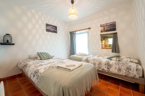 Bright bedroom at Espace Ker Gana in Plourin with three beds, terracotta floors, and coastal décor