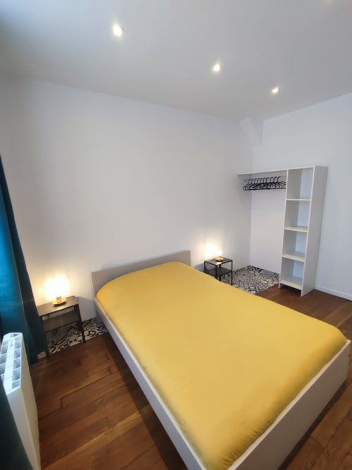 Chambre lumineuse à Lesdoucesnuits45 à Montargis avec literie jaune, mobilier blanc, parquet et éclairage encastré
