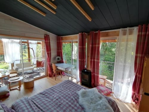 Chambre lumineuse avec vue sur la montagne à la Furanelle B&B à Saint Etienne, lit, bureau, cheminée et rideaux rouges