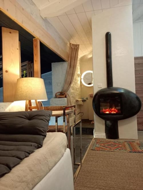 Chambre loft moderne à la B&B Furanelle à Saint Etienne avec foyer suspendu noir, touches de bois et vue sur les montagnes