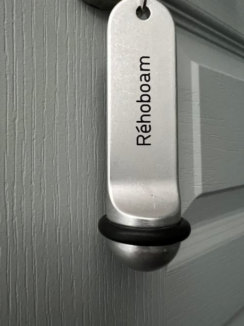 Accroche-porte argentée avec le texte « Réhoboam » à la chambre d'hôtes Le Petit Château à Baye, France