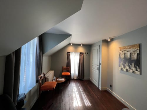 Jéroboam room at Le Petit Château B&B in Baye, France, featuring angled ceiling, dark wood floors, orange seating, and garden