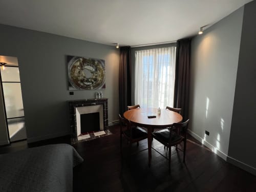 Salomon room at Le Petit Château in Baye featuring sitting area with round table, fireplace, and garden view