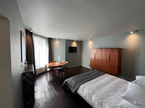 Salomon room at Le Petit Château B&B in Baye, France with bed, wooden wardrobe, dining table and garden view