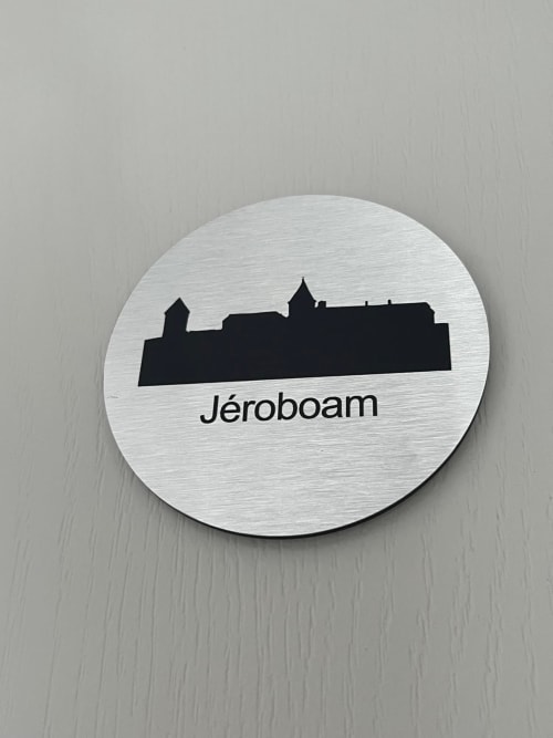 Panneau de la chambre Jéroboam au Petit Château B&B à Baye, France, avec silhouette de château sur cercle en métal brossé