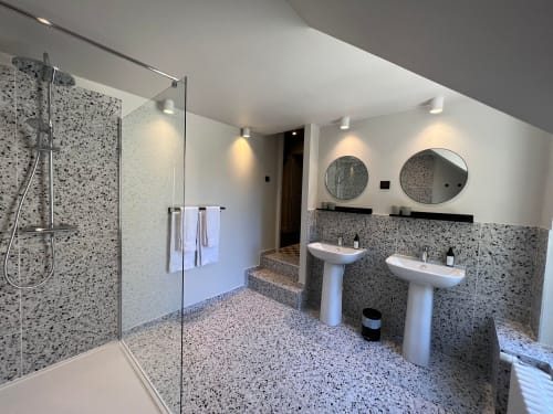 Moderne badkamer in Le Petit Château BnB in Baye met terrazzo tegels, dubbele wastafel, ronde spiegels en inloopdouche