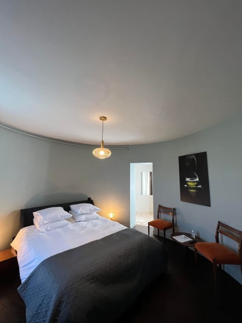 Ruime slaapkamer in Souverain Tower bij Le Petit Château B&B, Baye, met moderne hanglamp en uitzicht op de tuin