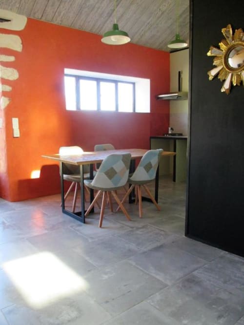 Salle à manger contemporaine de l'Appartement Éléphant au Mas du Fort, Gargas avec mur d'accent rouge, table à manger et vue sur le jardin