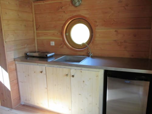 Kitchenette équipée en caravane climatisée au Mas du Fort à Gargas avec hublot, évier et acier inoxydable