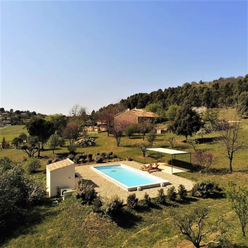 Le Mas du Fort B&B à Gargas dispose d'une piscine turquoise avec transats, entourée de verdure et d'une ambiance rustique