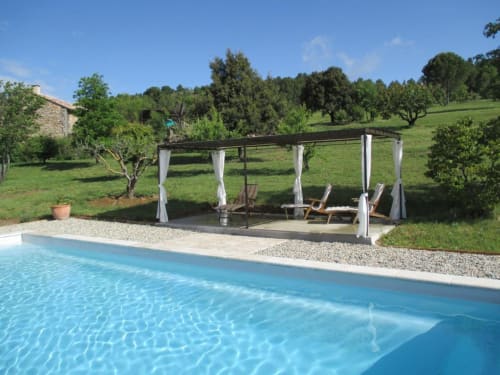Zone piscine du Mas du Fort avec pergola et transats donnant sur la campagne verdoyante à Gargas, France