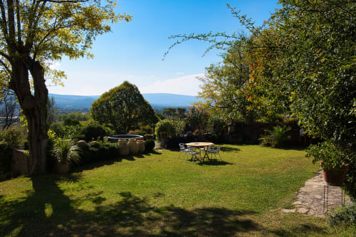 Jardin luxuriant avec pelouse soignée, arbres et espace repas avec vue sur la vallée de Gargas au Mas du Fort, Provence