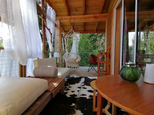 Chambre sur pilotis à la Furanelle B&B à Saint-Étienne avec poutres en bois, coin séjour, table à manger et vue sur les montagnes depuis le balcon