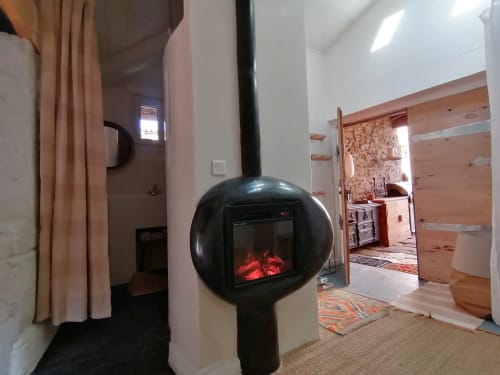Foyer électrique design noir en pod dans la Chambre sur Pilotis de la Maison d'hôtes Furanelle à Saint Étienne, créant une ambiance chaleureuse avec vue sur les montagnes