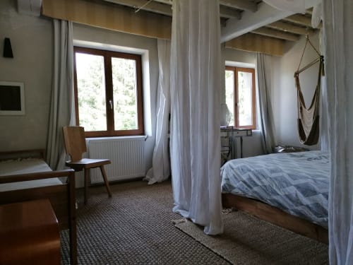 Chambre spacieuse à la Furanelle B&B à Saint Etienne avec lit à baldaquin, vue sur les montagnes et coin détente avec fenêtres