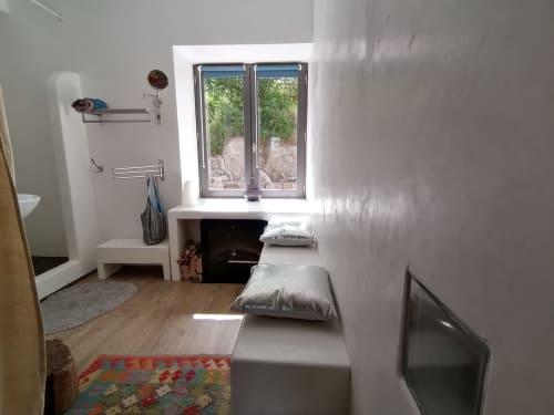Chambre lumineuse aux murs blancs, parquet, lits jumeaux, rangements, portes vitrées donnant sur la montagne
