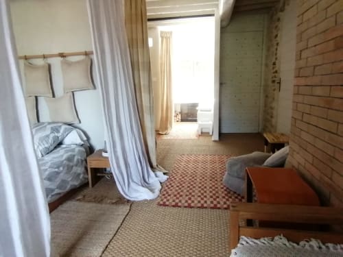 Chambre spacieuse à la Furanelle B&B à Saint Etienne avec lit à baldaquin, coin salon, mur de briques et vue sur les montagnes